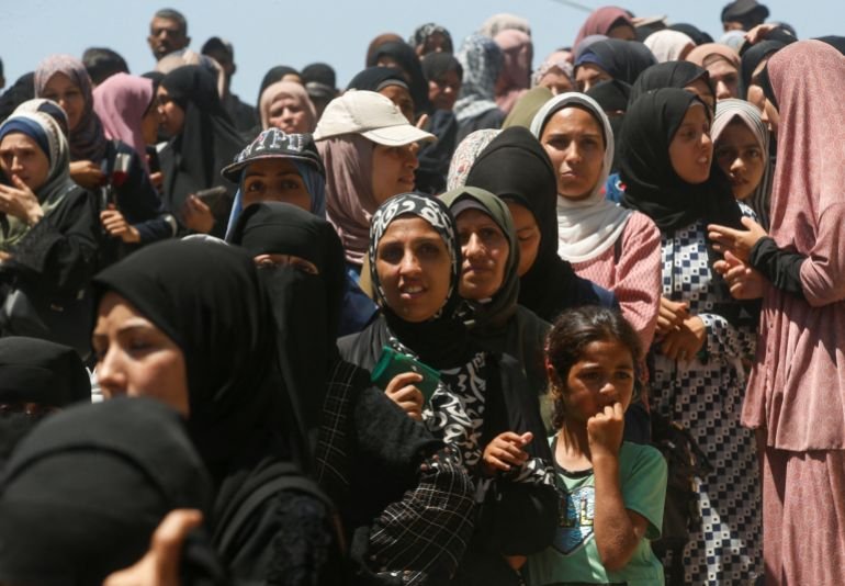 Palestinians gather to receive aid, including food supplies, at a distribution center in Gaza City, June 26, 2025. REUTERS/Mahmoud Issa