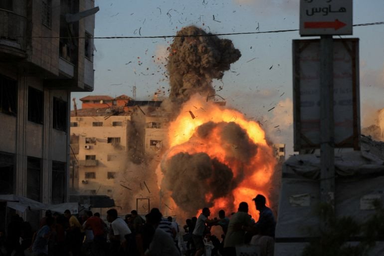Palestinians react, as smoke and flames rise while a residential building collapses after an Israeli air strike, in Gaza City, September 7, 2025. REUTERS/Dawoud Abu Alkas TPX IMAGES OF THE DAY