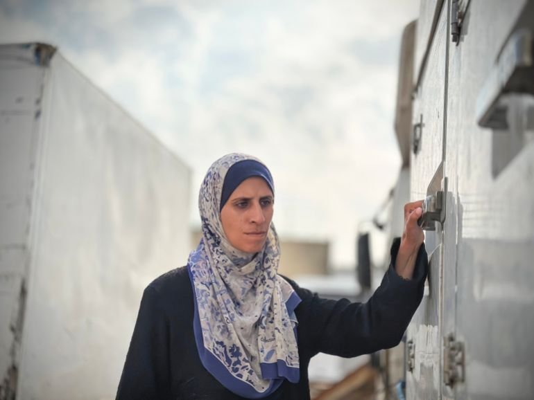 Israa al-Areer waits outside a mortuary fridge