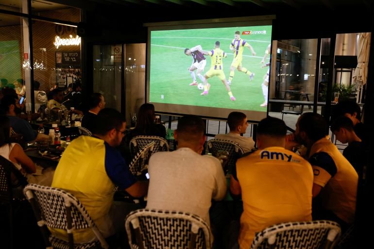 Israeli supporters of Maccabi Tel Aviv soccer team watch the team play against Aston Villa in the Europa League