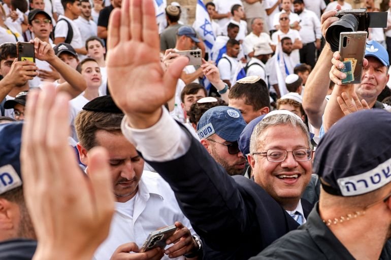 a man in a suit smiles in a crowd