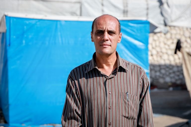 Man stands in front of blue tarp