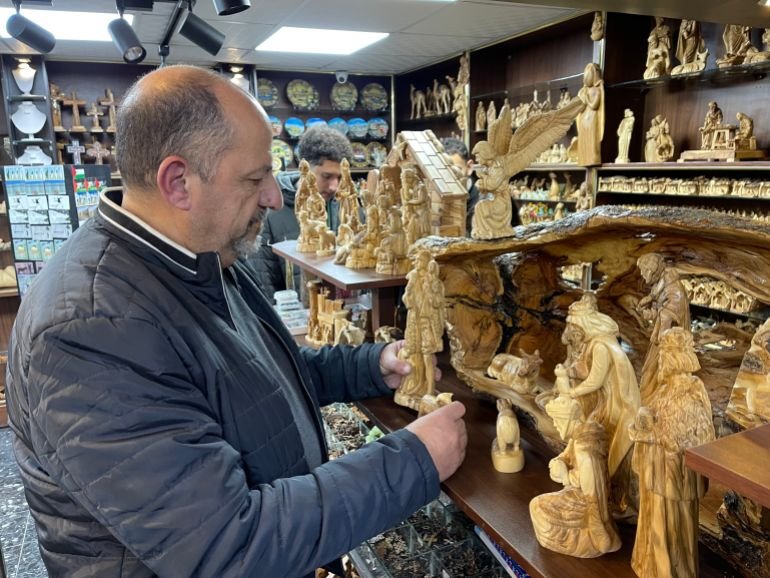 Jack Jaqman, owner of an Oriental antiques shop, arranges traditional artifacts