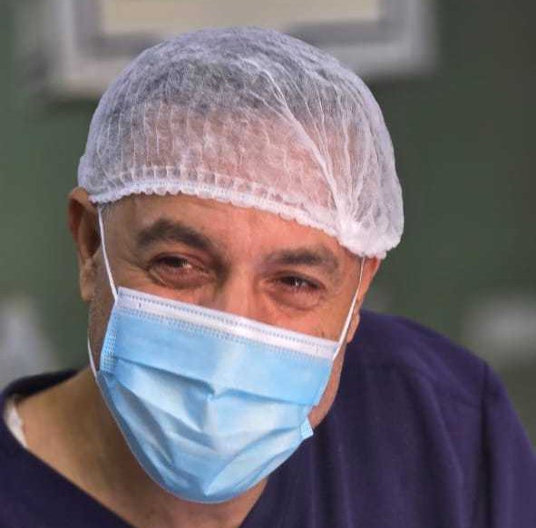 small square photo of smiling Dr Abu Saiya in a mask and cap