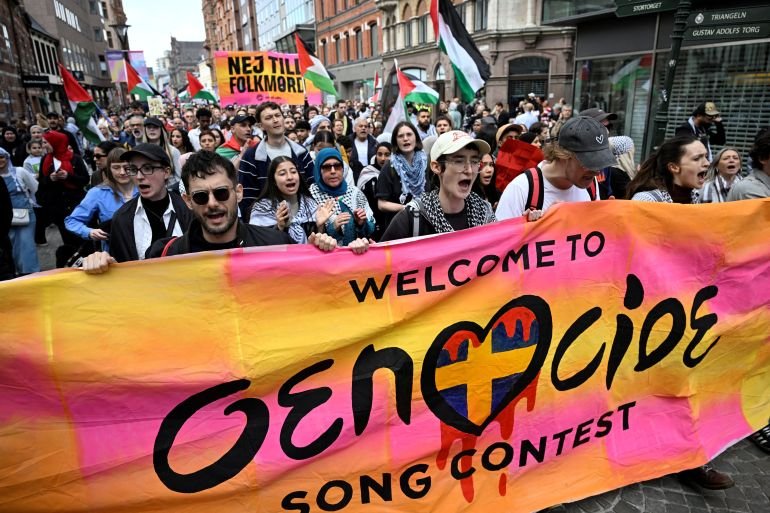 Protesters hold a banner and Palestinian flags during the "Stop Israel" demonstration, against Israel's participation in the Eurovision Song Contest due to its ongoing offensive in Gaza against Hamas, in Malmo, Sweden