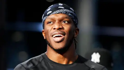 Getty Images  KSI smiles while wearing a black bandana and t-shirt 