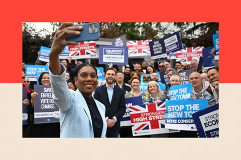 Getty Images Conservative Party Leader Kemi Badenoch takes a selfie during a visit to Thompsons of Crews Hill garden centre in Enfield 

