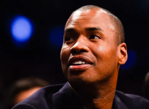 Alex Goodlett / Getty Images A close up portrait shows Collins smiling slightly looking to the left of frame with a dark bokeh background, taken in New York in 2014.