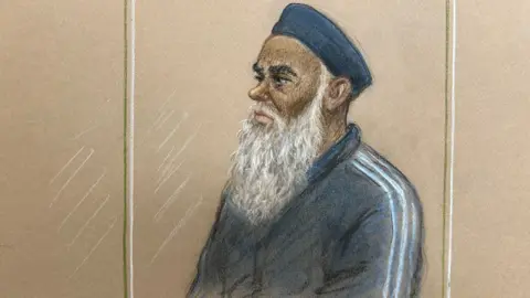 Julia Quenzler/BBC Court sketch shows a man in dock. He has a long, grey beard and is wearing a kufi
