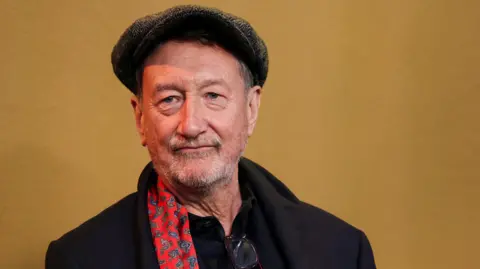 Reuters Steven Knight in a Peaky Blinders-style flat cap at the premiere of Peaky Blinders: The Immortal Man on 2 March 2026