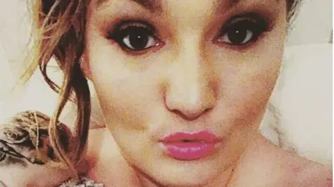 Michaela Allen A selfie of Michaela Allen, she is wearing pink lipstick and has her hair styled in an up do. 