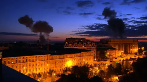 BBC/Lee Durant Smoke rises over buildings in central Kyiv at night