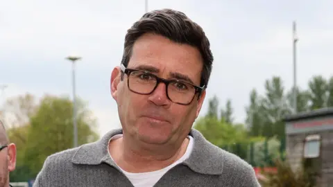 Getty Images Andy Burnham in a grey sweater and white T-shirt arriving for a charity football match