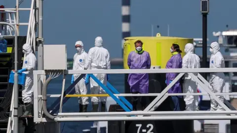 Reuters people in protective gear on board the MV Hondius in Rotterdam
