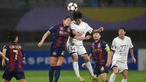 AFP via Getty Images Pak Ye Gyong (C) of Naegohyang Women's FC fights for the ball with Haruhi Suzuki (2nd L) of Suwon FC Women during the AFC Women's Champions League semi-final football match between North Korea's Naegohyang Women's FC and South Korea's Suwon FC Women in Suwon on May 20, 2026
