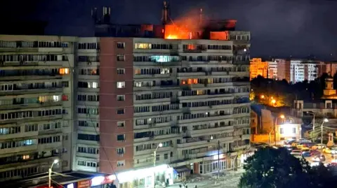 DSU via Reuters A small fire is seen on top of a multi-storey building at night in Galati, Romania on Friday.
