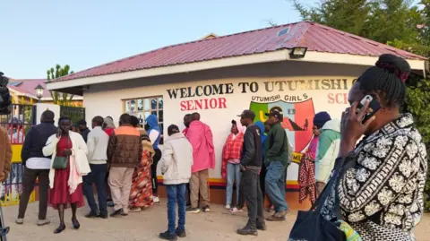Robert Maina A crowd outside the Utumishi Academy school in Gilgil, Kenya