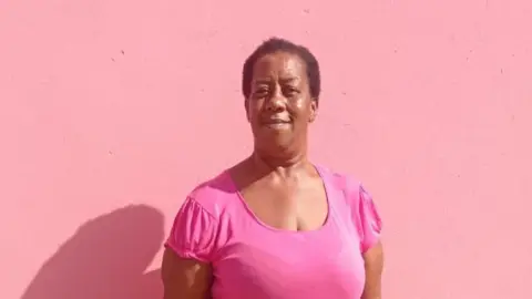 Miranda Beazer Miranda Beazer wearing a pick top against a pink backdrop