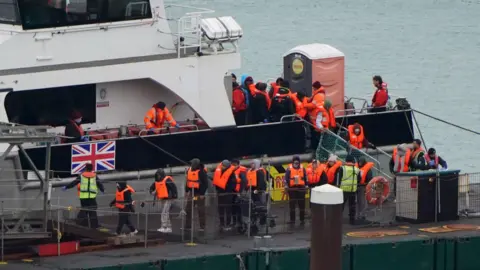 PA Media A group of people thought to be migrants are brought in to the Border Force compound in Dover, Kent, from a Border Force vessel following a small boat incident in the Channel.