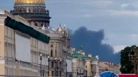 Reuters A picture taken from the ground where Black smoke can be seen rising over a golden-domed building in the Russian city of St Petersburg.