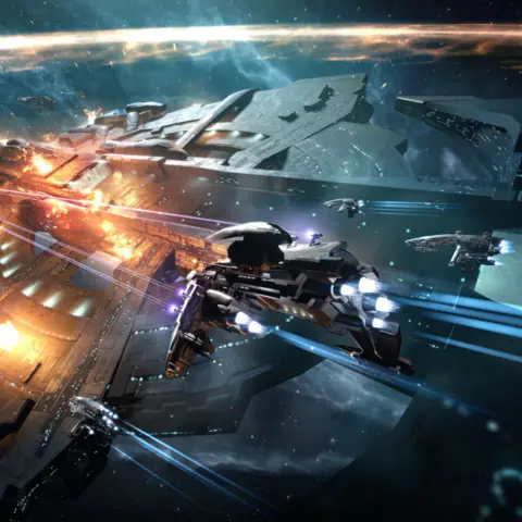 Fenris Creations A large EVE Online ship under attack, its hull lit by explosions and energy fire as smaller ships dart around it, firing blue engine trails and weapons across a star-filled backdrop.