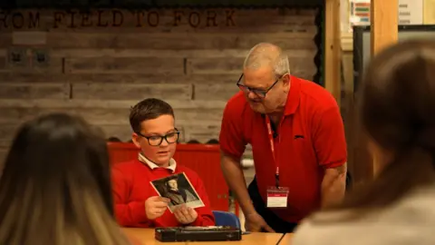 A pupil shows a man a photo