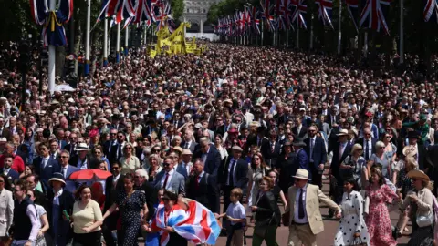 EPA/Shutterstock Crowds make their way up The Mall outside Buckingham Palace