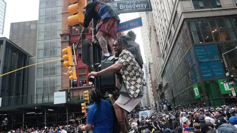 Getty Images Knicks fans climbing on top of a stop light