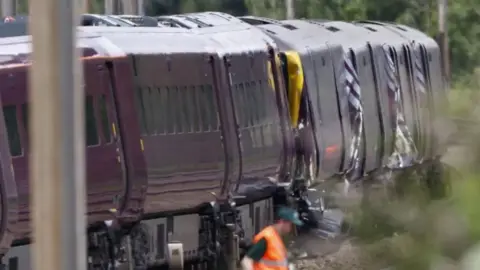 TOLGA AKMEN/EPA/Shutterstock Two crashed, purple trains.