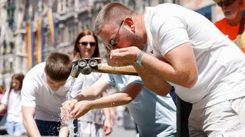 Getty Images A man drinking from a water fountain in Munich 
