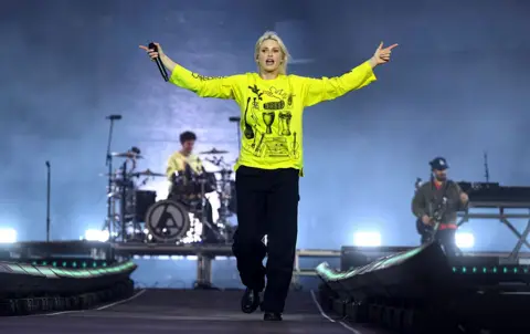 Getty Images Emily Armstrong of Linkin Park, dressed in bright green, performs onstage during Download Festival 2026 at Donington Park.