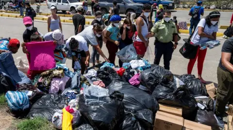Reuters People queue for clothing donations on the streets of Caraballeda, in La Guaira state