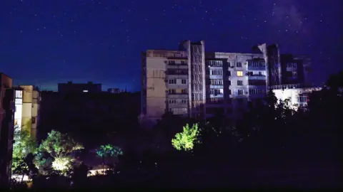 Reuters Residential buildings at night during a temporary power outage, which local authorities said was caused by technological disturbances in the peninsula’s energy grid