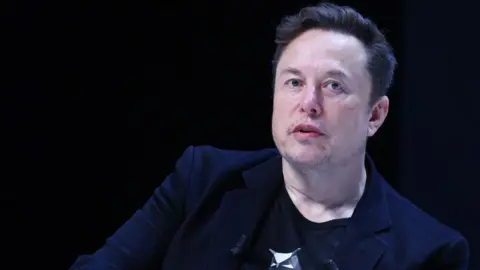 Getty Images Elon Musk in a black shirt with a silver owl and a black blazer speaking during the Cannes Lions International Festival in Cannes, France.

