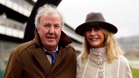 PA Media Jeremy Clarkson and Lisa Hogan on day four of the 2025 Cheltenham Festival at Cheltenham Racecourse. 