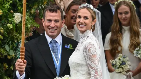 Reuters A man in a suit is stood next to a woman in a bride's dress.