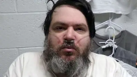 Utah Department of Corrections A man with black hair and a long black/grey beard has a breathing tube in his nose