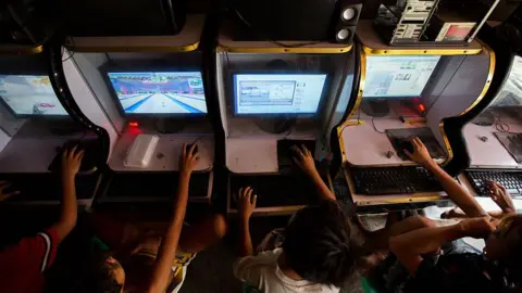 Getty Images A row of children playing computer games at an internet cafe in the Philippines