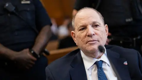 Bloomberg via Getty Images Close-up of Weinstein in court, wearing a blue suit and blue and white tie