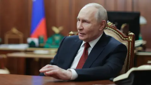 EPA Putin sat at a desk