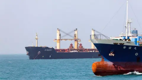 Reuters Two blue ships on a  bright blue sea.