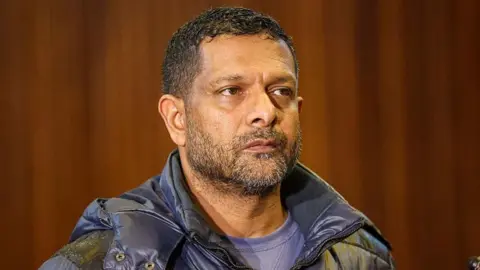 Gallo via Getty Images South Africa's deputy head of crime intelligence Feroz Khan is seen in court. He has short hair and a short beard