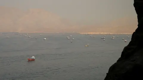 REUTERS/Stringer TPX IMAGES OF THE DAY The Strait of Hormuz is shown from a  dsitance w several tankers and freight boats. There are mountains in the foreground and in the distance.