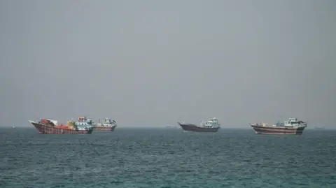Reuters Four large boats drifting on the Strait of Hormuz as seen from Oman.