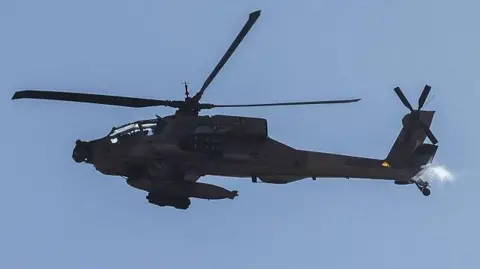 Getty Images This picture taken from a position in northern Israel, on the border with southern Lebanon, shows an Israeli Air Force AH-64 Apache helicopter flying on 4 June 2026. 