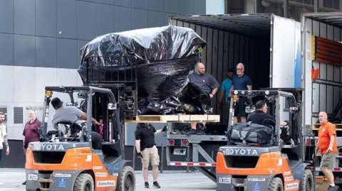 Getty Images Crew members are seen unloading trucks and transporting large boxes and items under tarpaulin into Madison Square Garden in preparation for the rumoured wedding of Taylor Swift and Travis Kelce