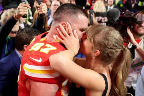 Getty Images Travis Kelce #87 of the Kansas City Chiefs kisses Taylor Swift after defeating the San Francisco 49ers 25-22 in overtime during Super Bowl LVIII at Allegiant Stadium on February 11, 2024 in Las Vegas, Nevada