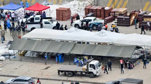 Reuters Two long tents, one white and one grey make up a makeshift morgue.