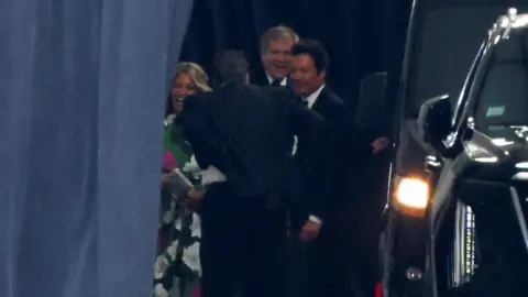 Reuters US TV presenter Jimmy Fallon arrives at Madison Square Garden behind a dark curtain.