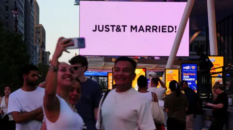 Reuters A woman pictured taking a selfie with the "JUST&T MARRIED" announcement